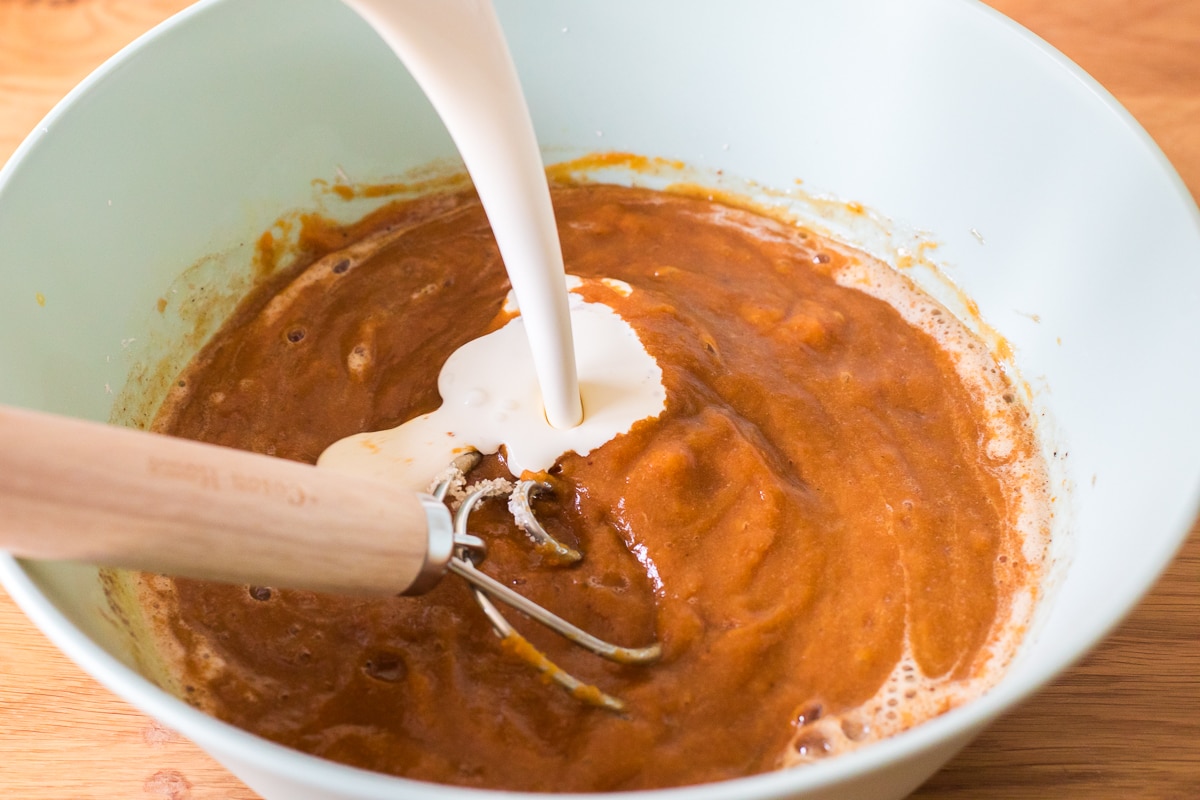 mixing dairy free heavy cream into a pumpkin pie mixture.