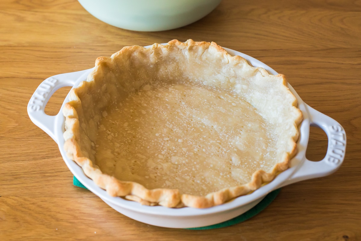 blind baked pie crust in a staub pie pan.