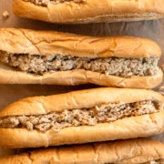 Close up of four chicken cheesesteaks with ground chicken and Cooper Sharp cheese on Amoroso rolls.