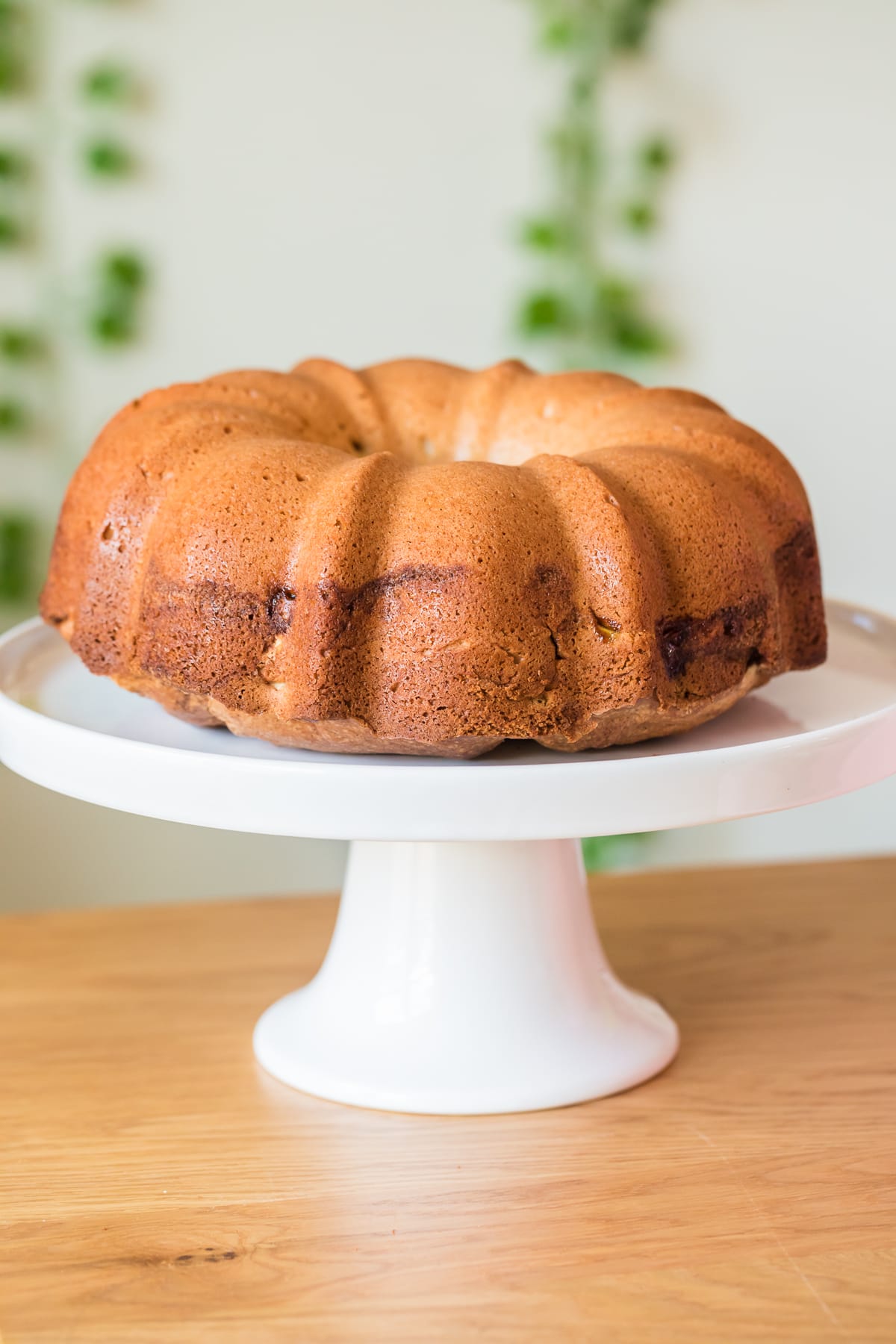 Jewish apple cake on a white cake stand.