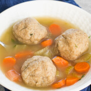 3 matzo balls in a bowl of chicken soup.