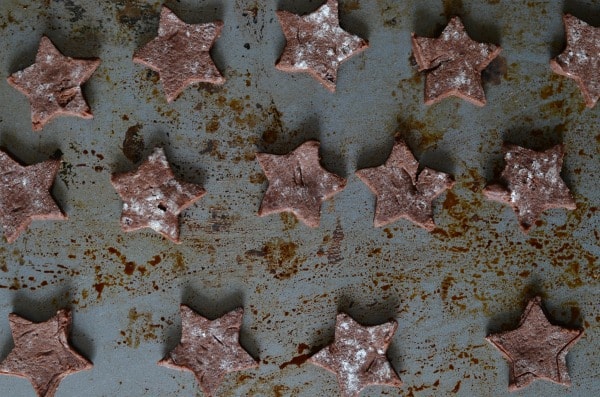 chocolate star cookies with cream cheese frosting and candy cane dust