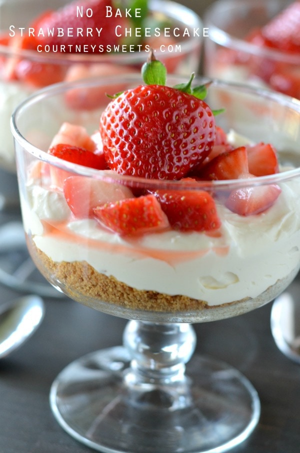 A glass bowl of cream with strawberries