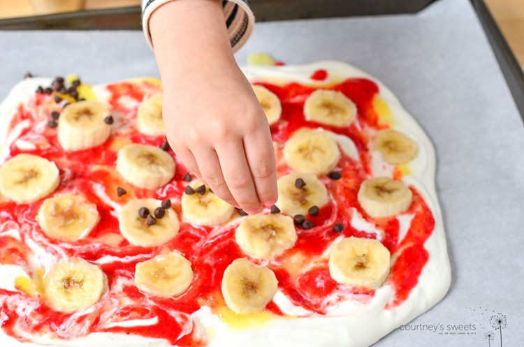 Banana Split Frozen Yogurt Bark, a refreshing frozen dessert for the whole family to enjoy. Using whole milk greek yogurt and fresh produce! Get this kid friendly recipe on www.courtneyssweets.com now for Mini Chef Mondays !