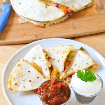 Chicken Quesadillas Recipe - Super easy restaurant style quesadillas made at home. We bake them in the oven to make them a bit of a healthier option, no frying in a pan! Kid friendly recipe on Mini Chef Mondays