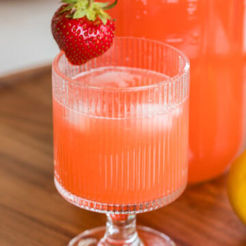 close up of strawberry lemonade in a glass with ice.