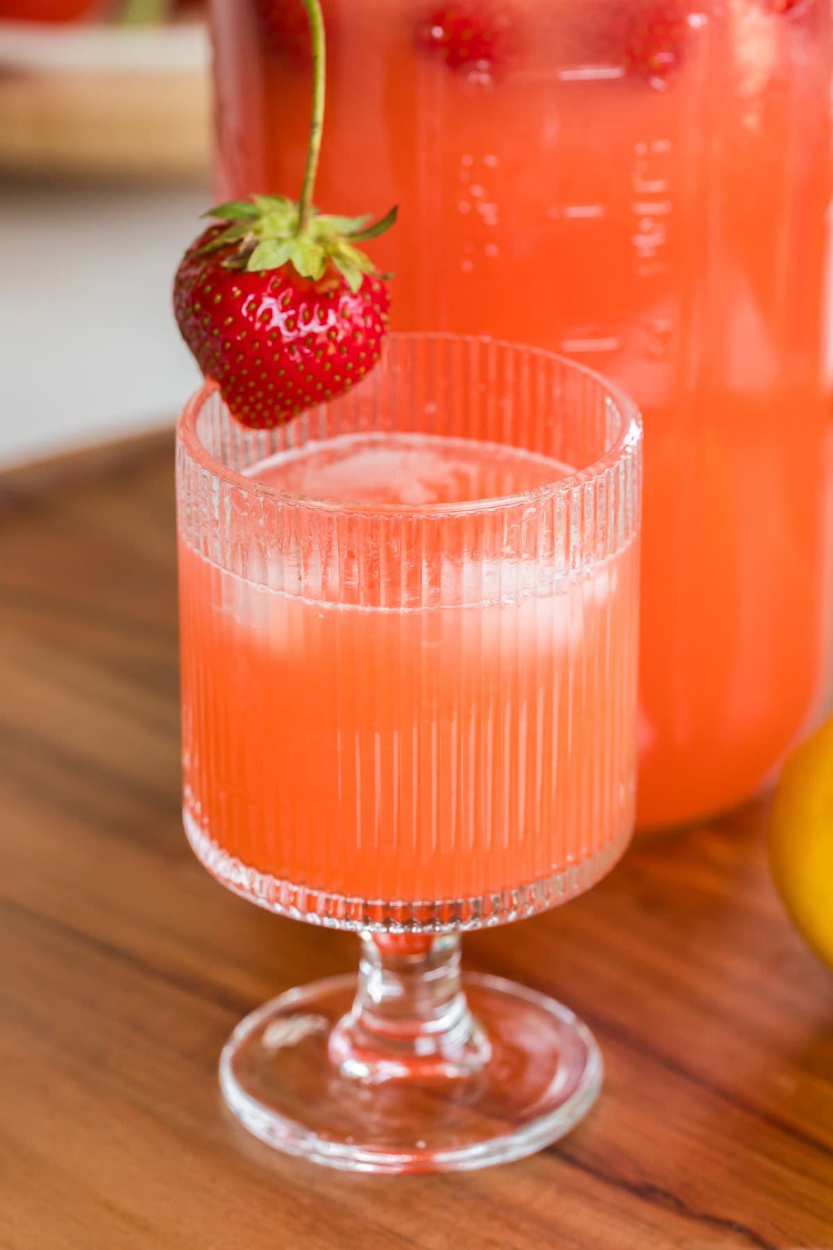 close up of strawberry lemonade in a glass with ice.