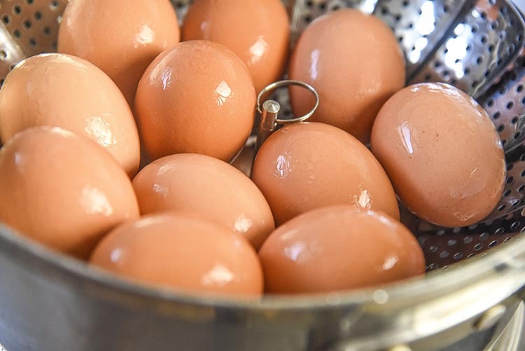 Steamed Hard Boiled Eggs results in an easy to peel hard boiled egg every time! Steaming hard boiled eggs allows you to skip waiting to use older eggs for hard boiling and you can use fresh eggs without any issues. Perfect for deviled eggs and of course Easter recipes ! eggs in steamer basket