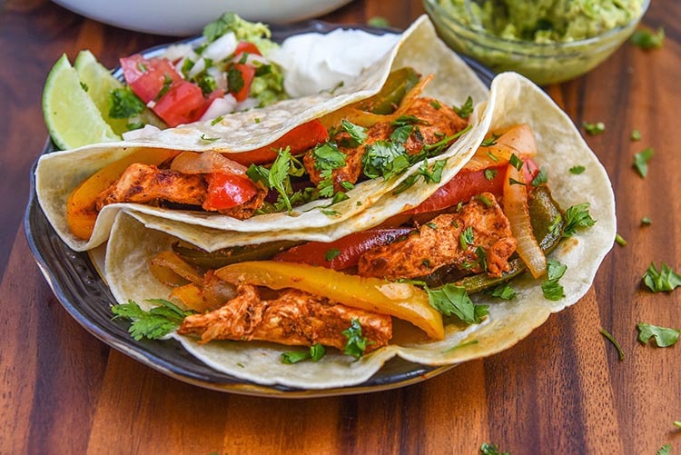 Celebrate Cinco de Mayo with homemade our Baked Chicken Fajita Recipe for dinner. Easy sheet pan meal recipe for the whole family, serve with sour cream, authentic pico de gallo or your favorite salsa recipe, fresh guacamole, and cilantro lime rice!