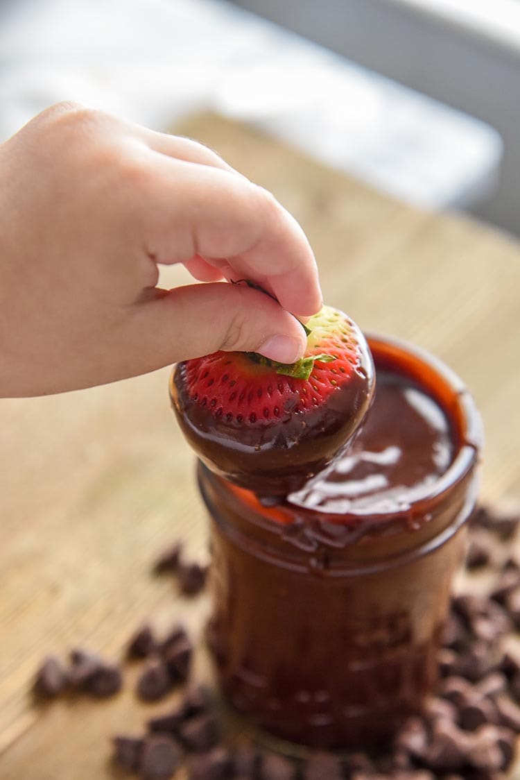 Our Easy Chocolate Ganache recipe can be the perfect fruit dip, chocolate ganache frosting, or even whip it for the best whipped chocolate ganache frosting. So easy to make and eat! Chocolate Covered Strawberry