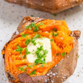 Our Air Fryer Baked Sweet Potato recipe results in a sweet potato baked to perfection! - Topped with butter, salt and parsley.