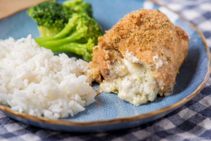  chicken stuffed with broccoli and cheese on a plate with rice and broccoli