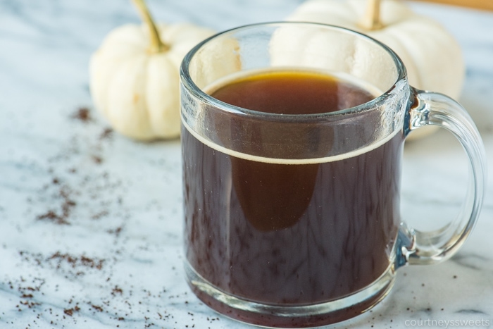 pumpkin spice coffee on a marble pastry board with white pumpkins