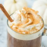 pumpkin spice coffee with whipped cream dusted with cinnamon and cinnamon stick