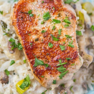 baked pork chops with rice asparagus and mushrooms on a blue plate