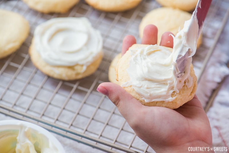 smearing vanilla frosting on white cake mix cookies