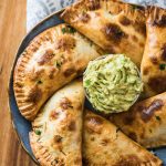 empanadas on a plate with guacamole