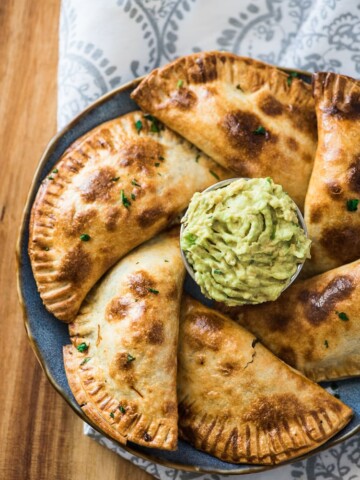 empanadas on a plate with guacamole