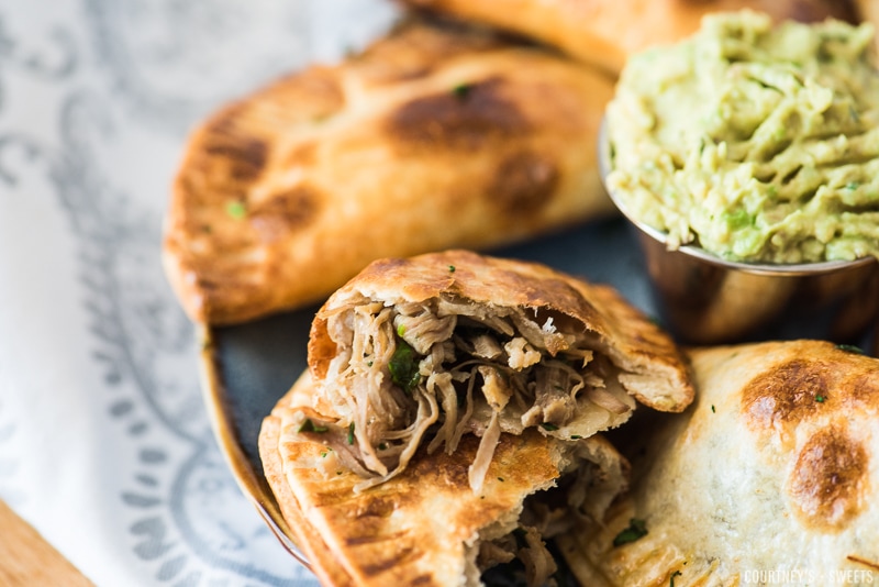 cut open pork carnitas empanadas on a plate