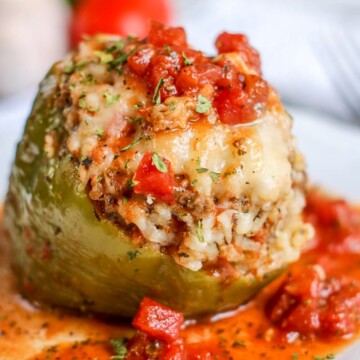 instant pot stuffed pepper on a plate covered in chunky tomato sauce