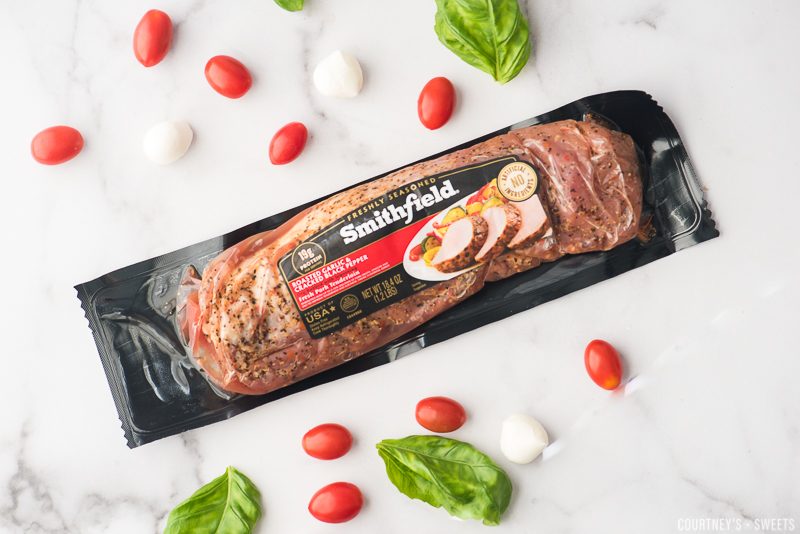 Smithfield packaged pork loin on a marble slab with mozzarella tomatoes and basil