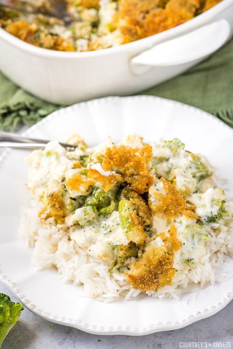 broccoli and cheese casserole over white rice on a white plate