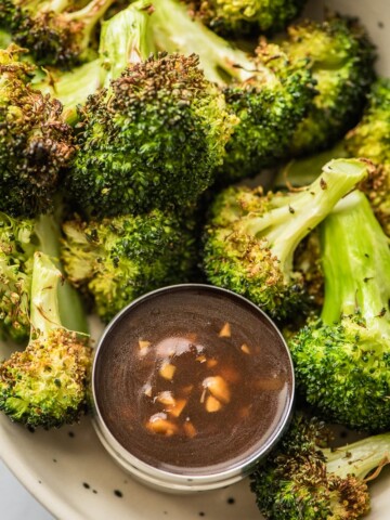 air fryer broccoli in a bowl with chinese garlic sauce in smaller bowl