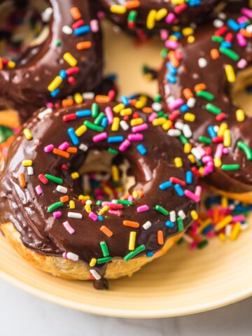 air fryer donuts with chocolate glaze and sprinkles on a yellow plate