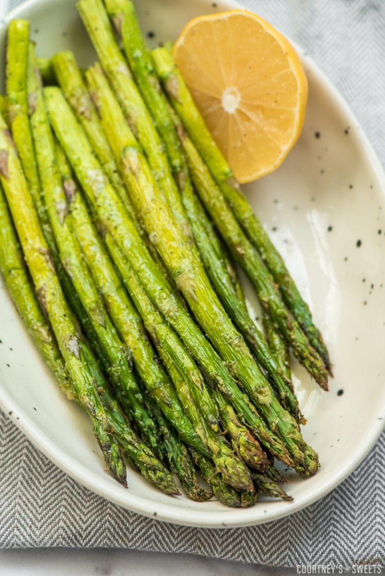 roasted asparagus in a bowl with half a lemon