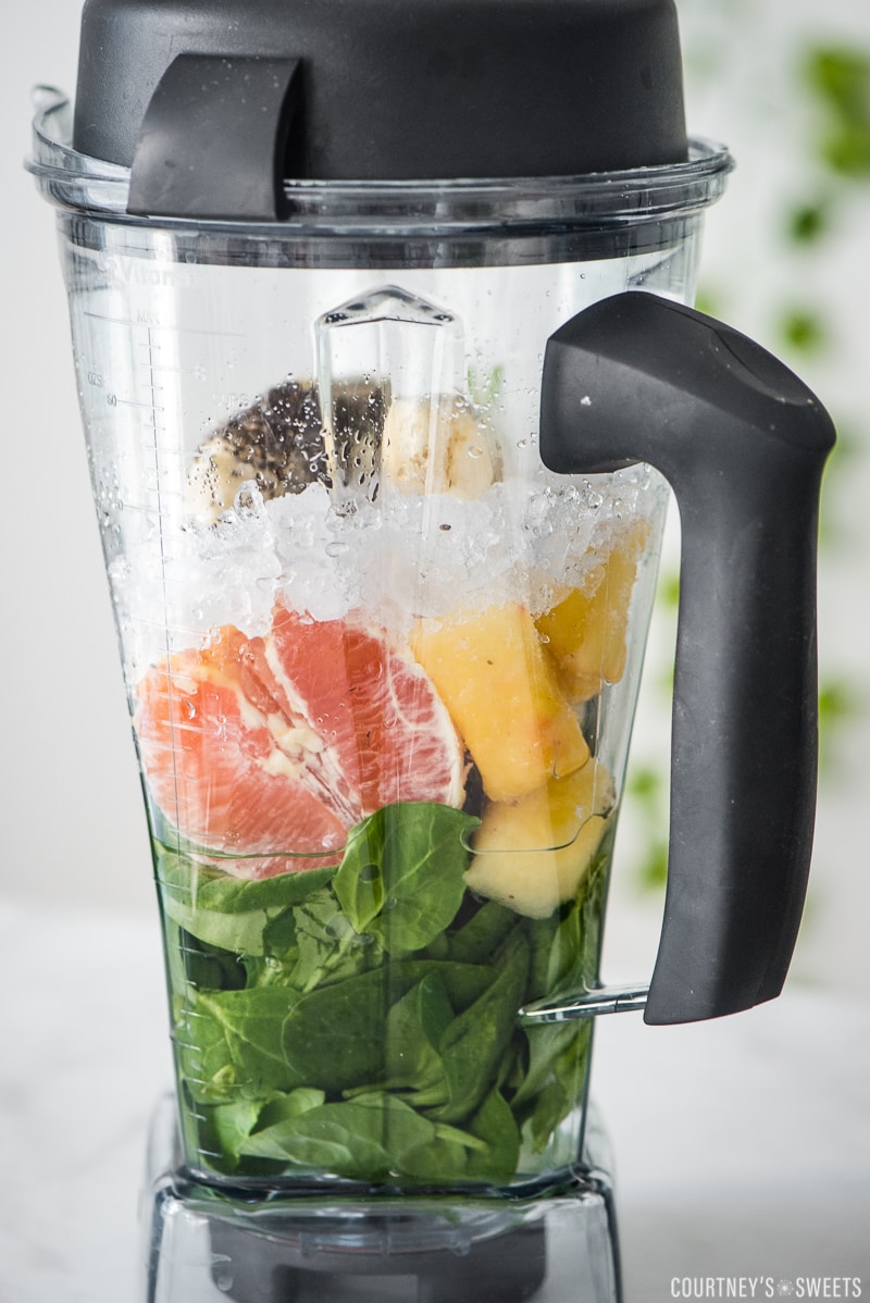 spinach orange mango pineapple chia seeds banana and ice in a vitamix blender
