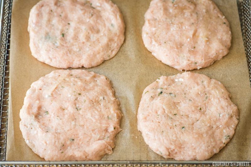 raw ground turkey burger on air fryer rack with unbleached parchment paper