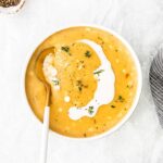 potato corn chowder with cream drizzle and spoon in bowl