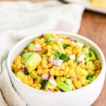 avocado corn salsa in a white bowl with linen napkin to the left