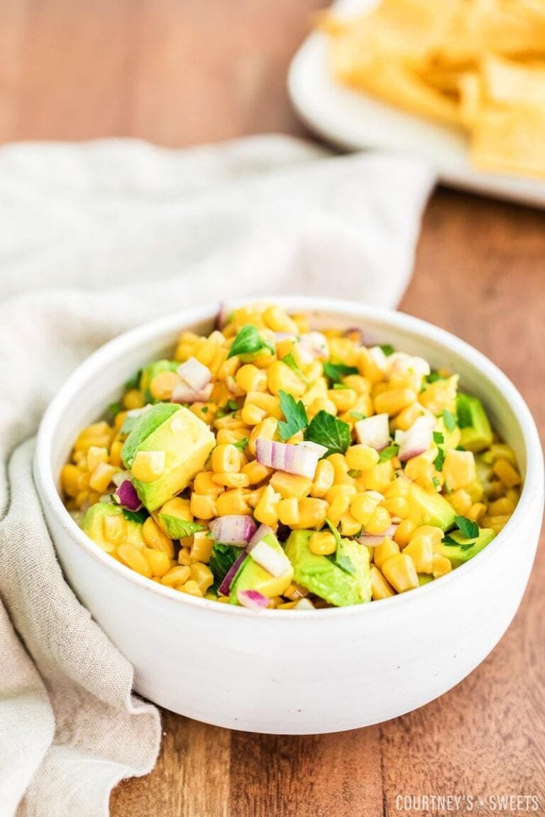 avocado corn salsa in a white bowl with linen napkin to the left