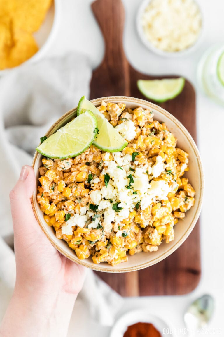 hand holding elote corn dip in low bowl