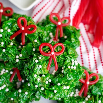 cornflake wreath cookies with twizzler bows on a marble slab with striped red napkin on the top right