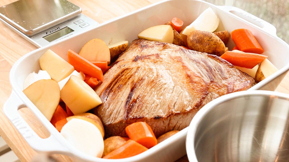 seared brisket with vegetables in a casserole dish.