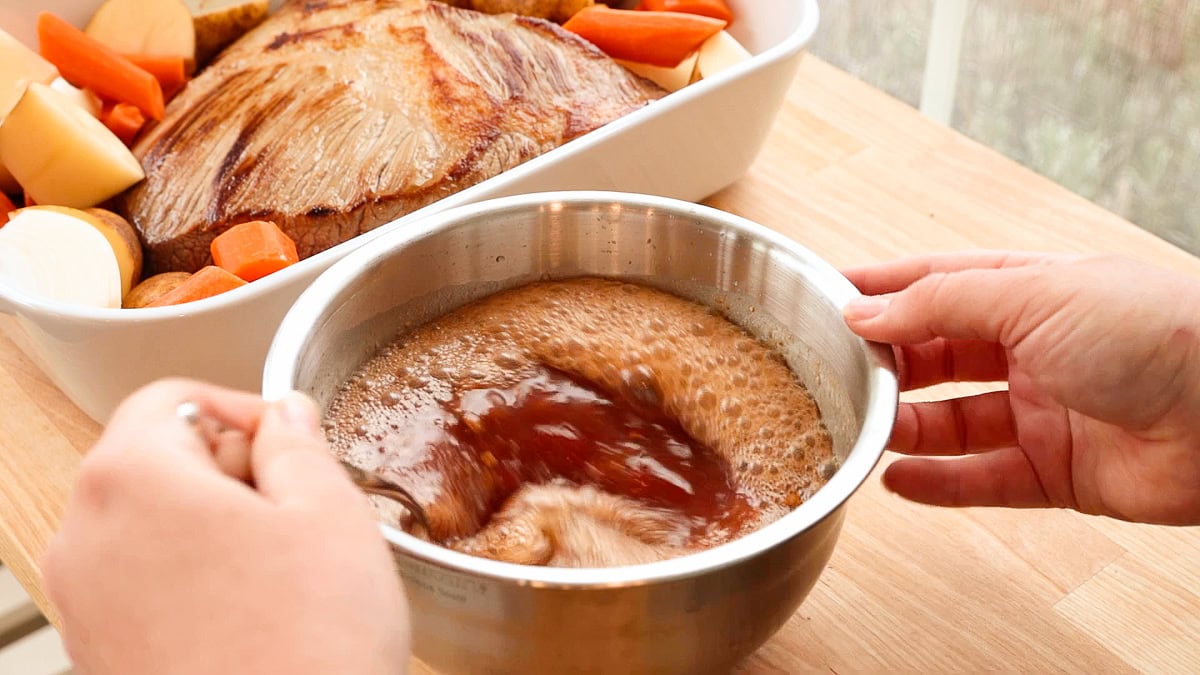 hands mixing ingredients in a bowl.