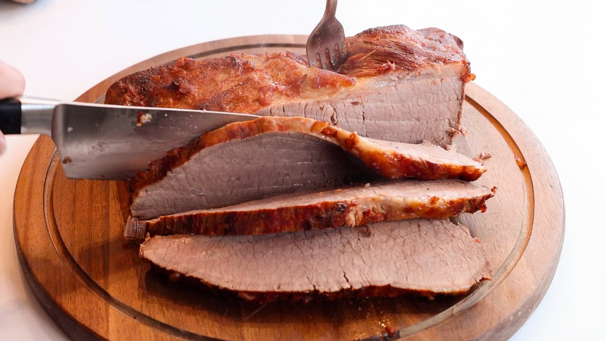 slicing brisket on a cutting board.