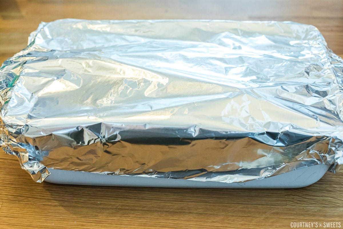 white casserole dish covered with tinfoil