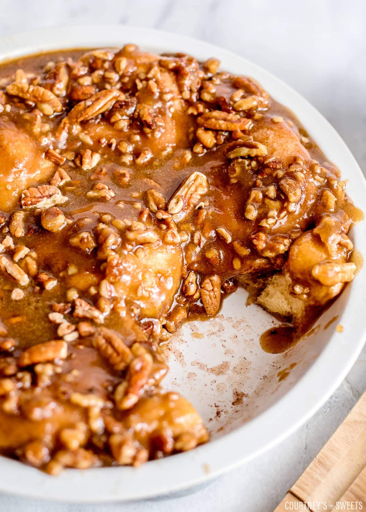 sticky buns in a ceramic dish with one missing