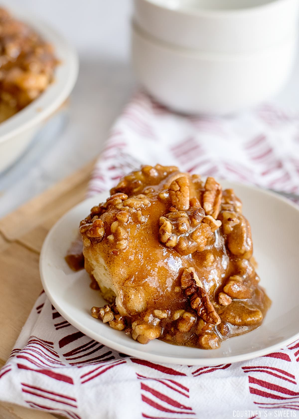 stick bun with pecans on a plate on a red and white napkin