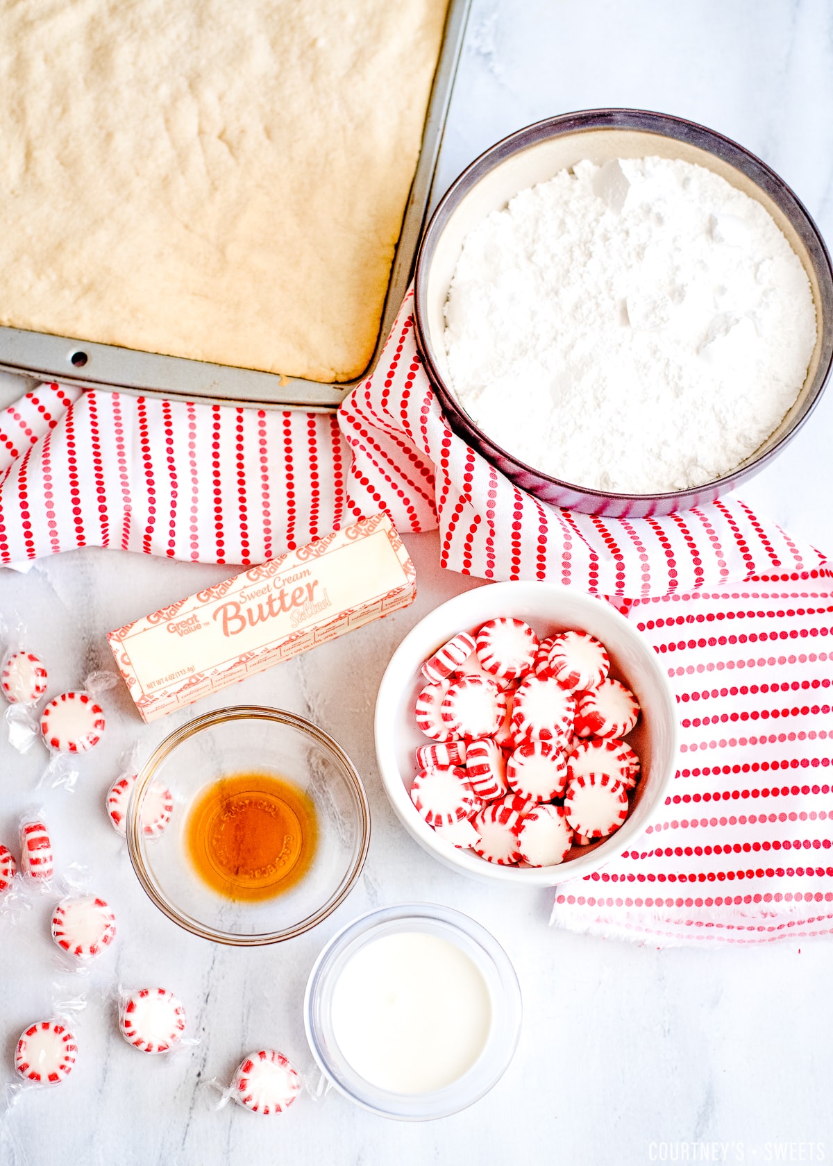 ingredients on a marble board for peppermint frosting with a red and white striped napkin