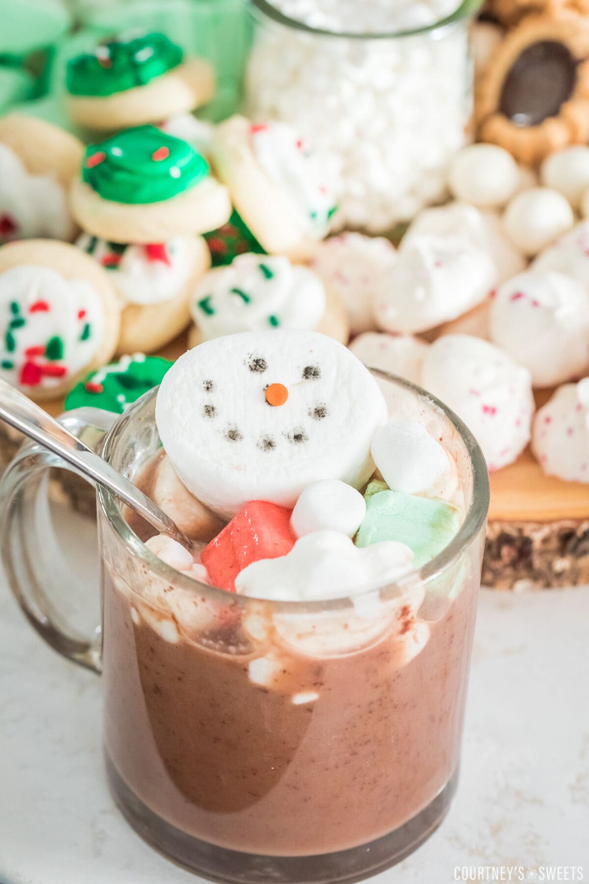 snowman marshmallow topped hot chocolate in front of hot charcuterie board