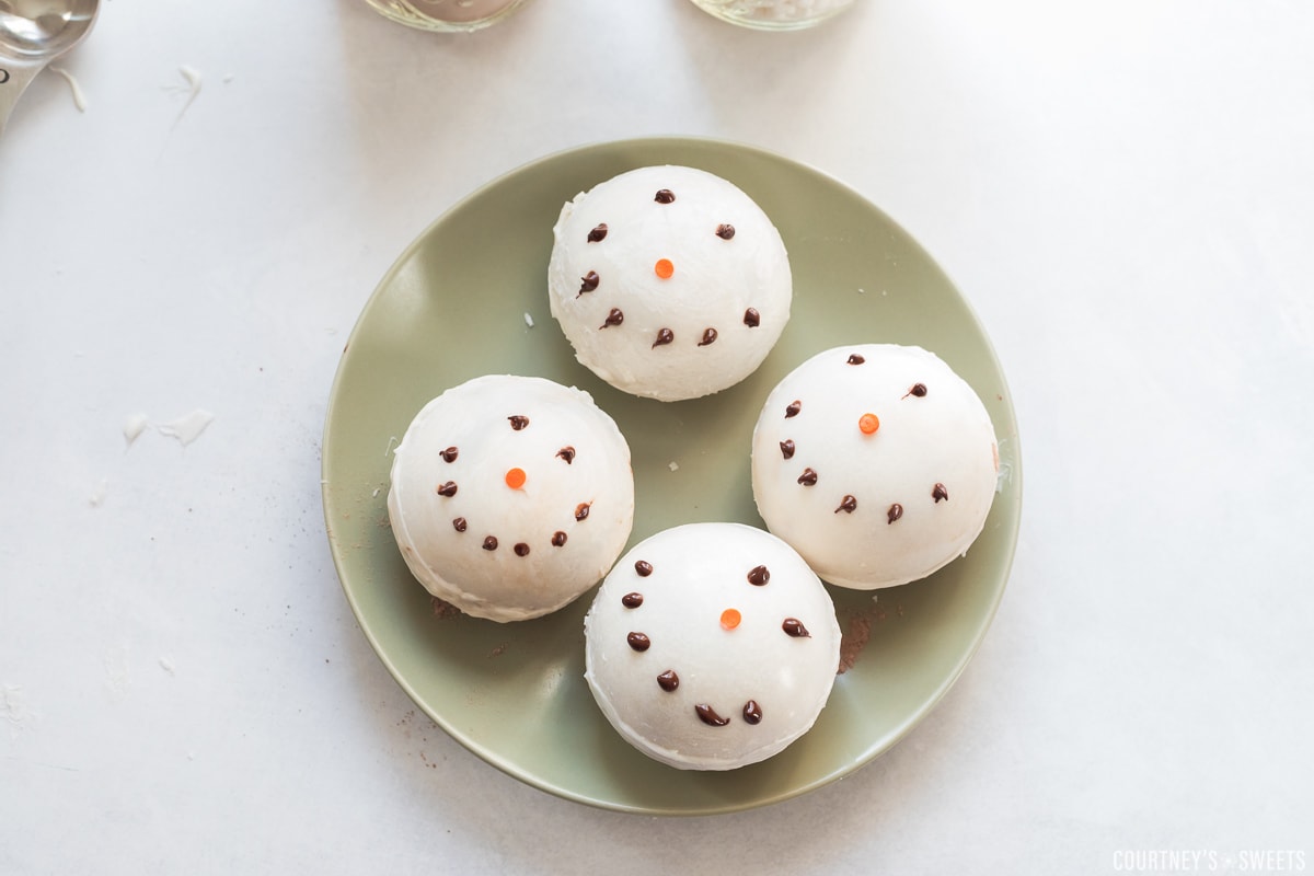 snowman hot chocolate bombs on a green plate