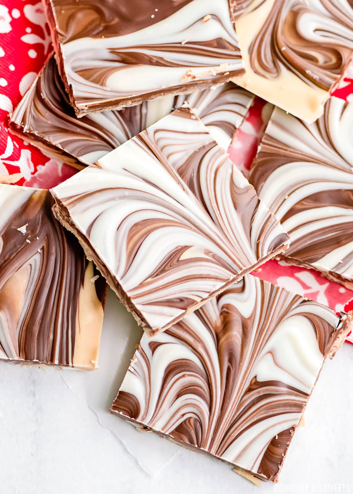 squares of tiger butter on a marble slab with red and white decorative napkin under it