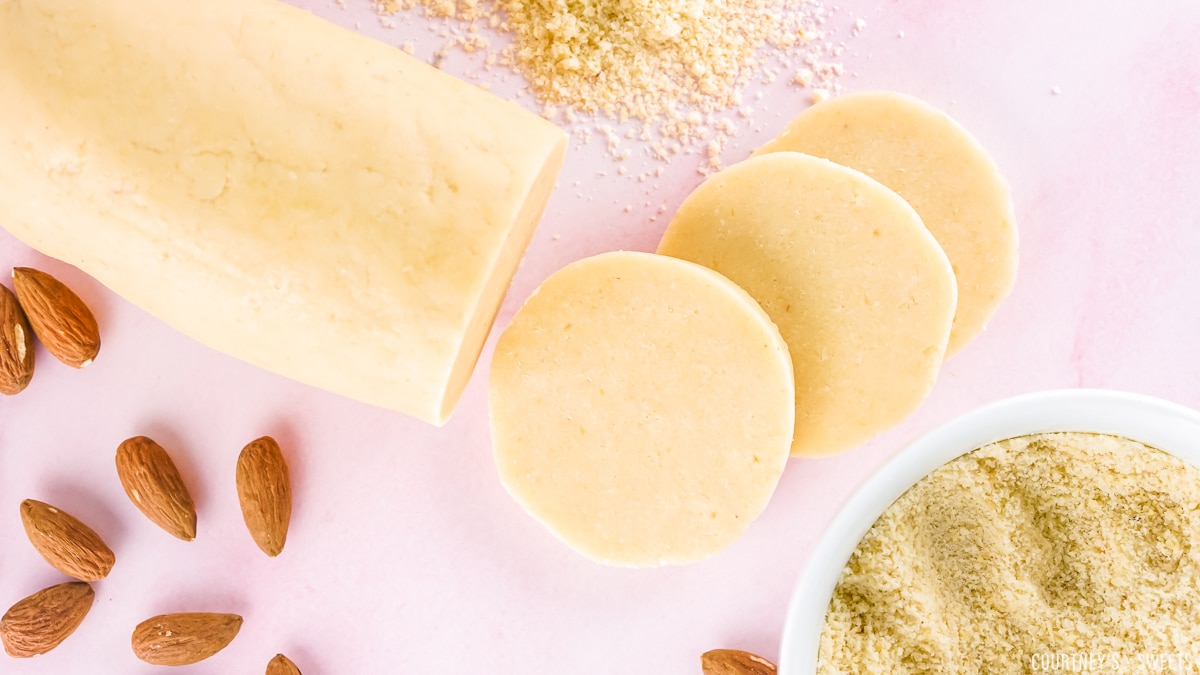 almond paste sliced and log on a pink backdrop.