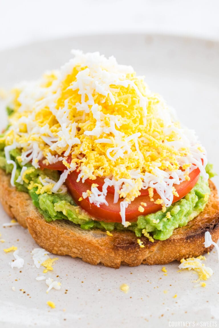 grated egg avocado toast on a neutral colored plate.
