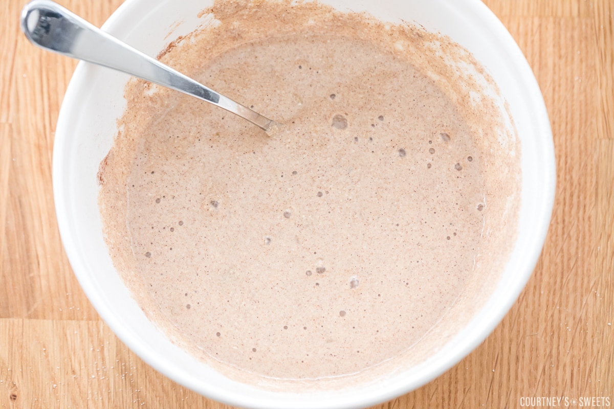 oat flour muffin batter in a white bowl with spoon.