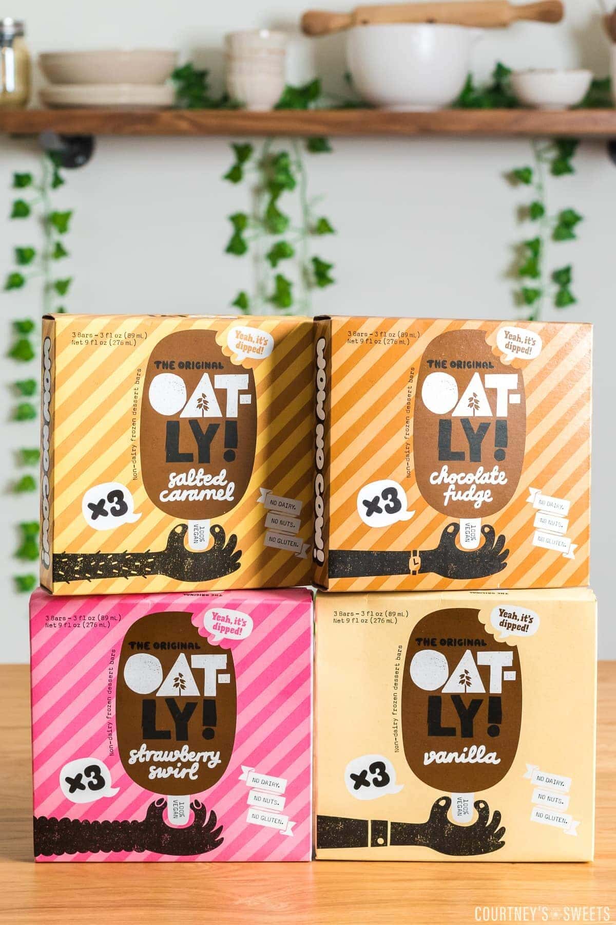 vertical photo of boxes of oatly dipped bars stacked.